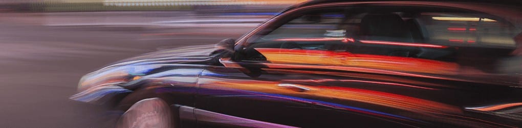 zoomed in image of a car speeding down the road