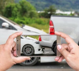 person taking a picture of a rear end car accident with their phone