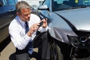 loss adjuster inspecting car involved in accident