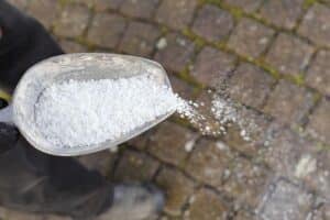 person spreading salt on a pathway