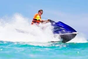 teenager jet skiing with a life jacket on