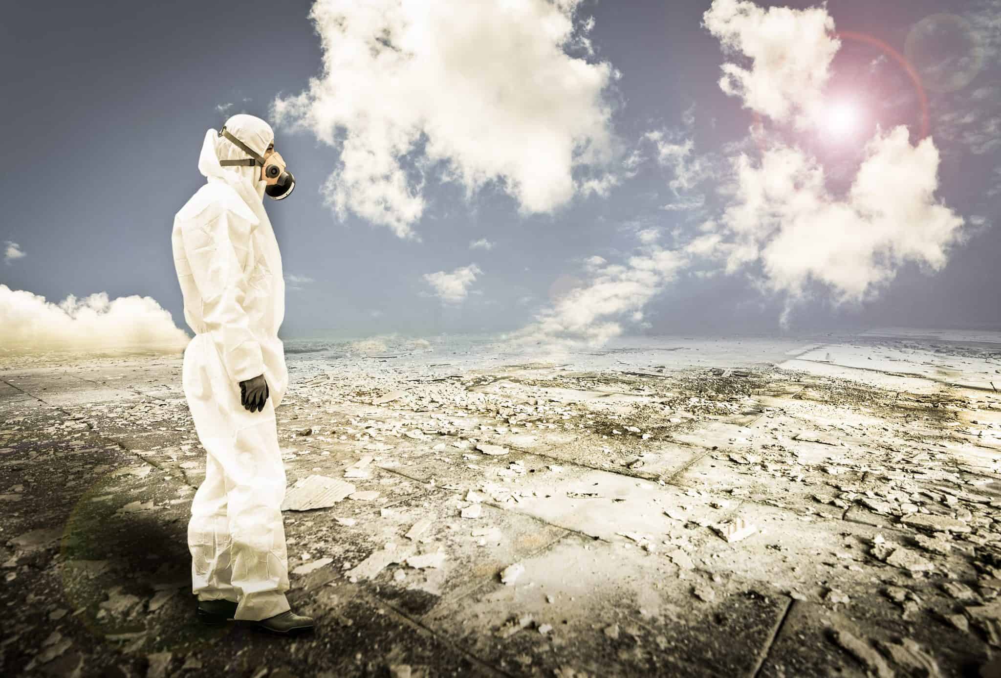 person in protective gear looking over a desolate area