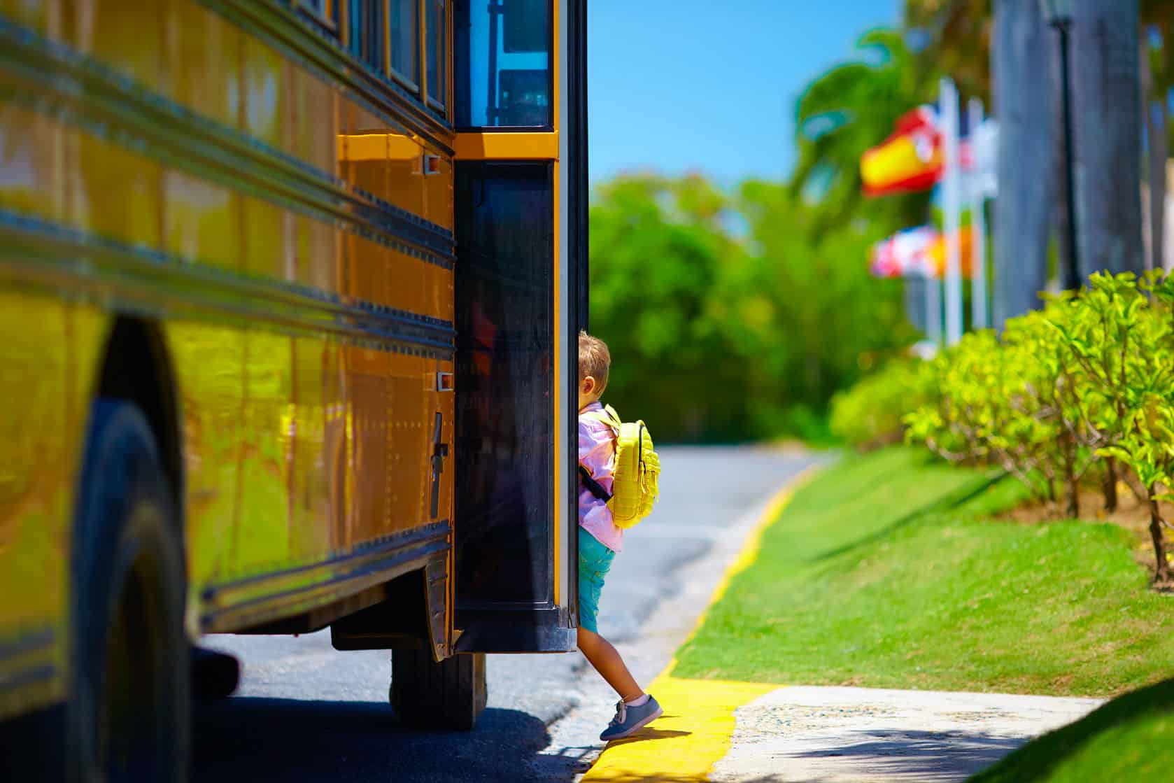 child getting on a school bus with a backpack on