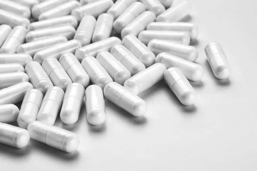 white pills across a white background