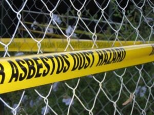 metal fence with asbestos warning tape on it
