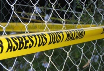 metal fence with asbestos warning tape on it