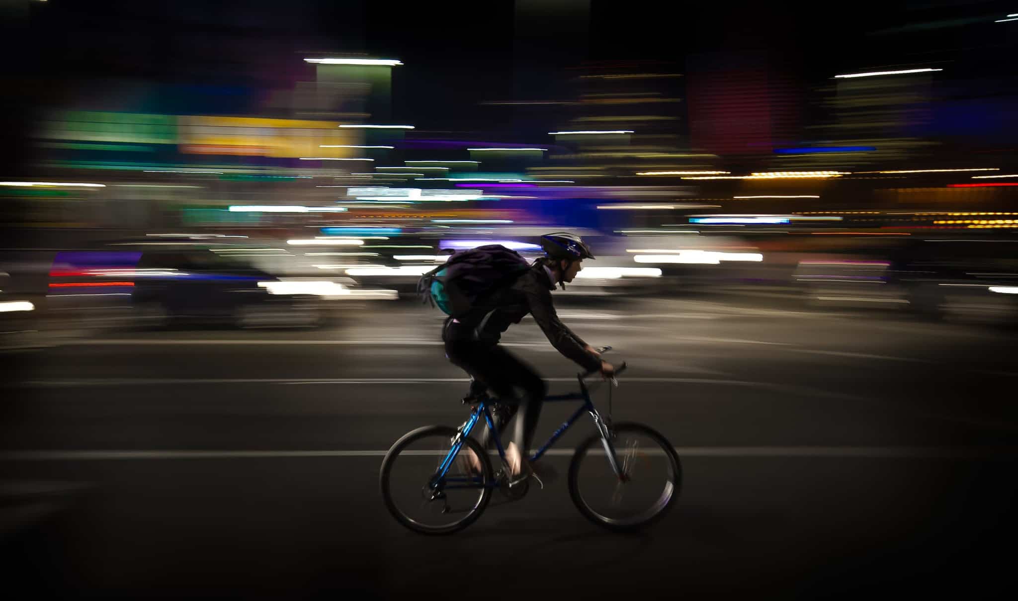 cyclist riding a bike with a blurred dark background