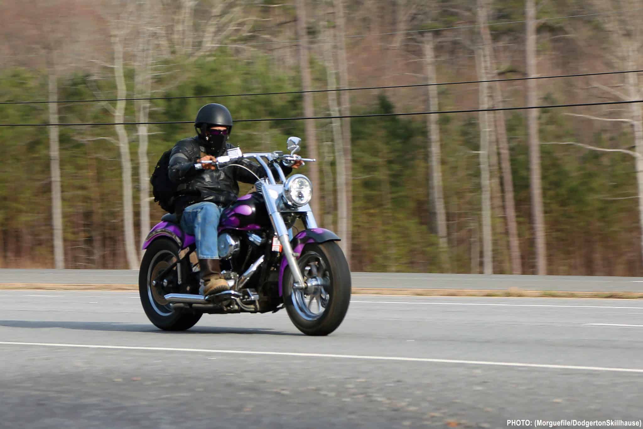 biker riding his motorcycle with a helmet and backpack on