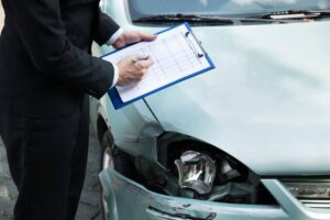 Insurance Agent Inspecting Car After Accident