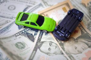 Toy cars demonstrating an accident on a background of 100 dollar bills