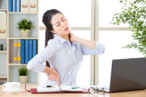 business woman with back pain and neck pain in office