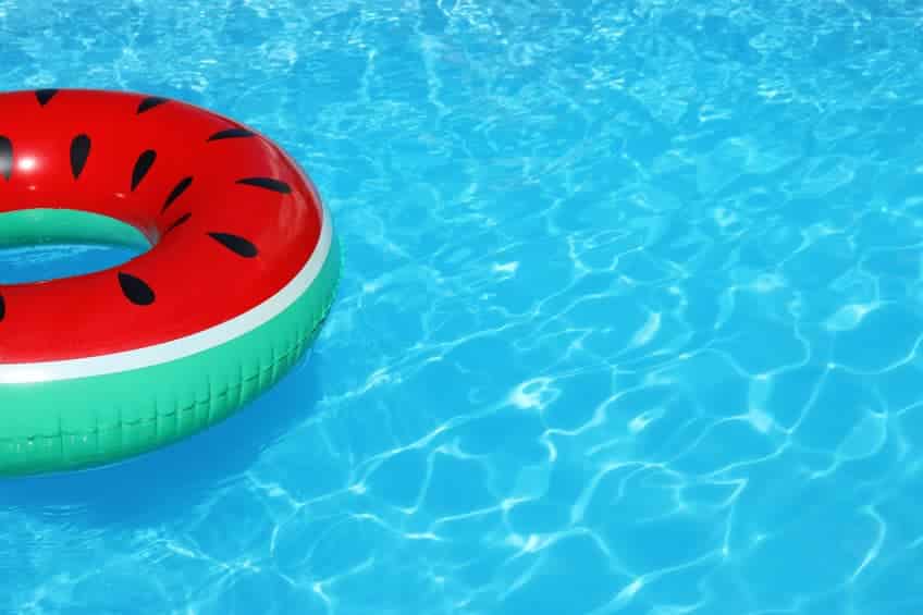 Inflatable ring floating in swimming pool on sunny day.