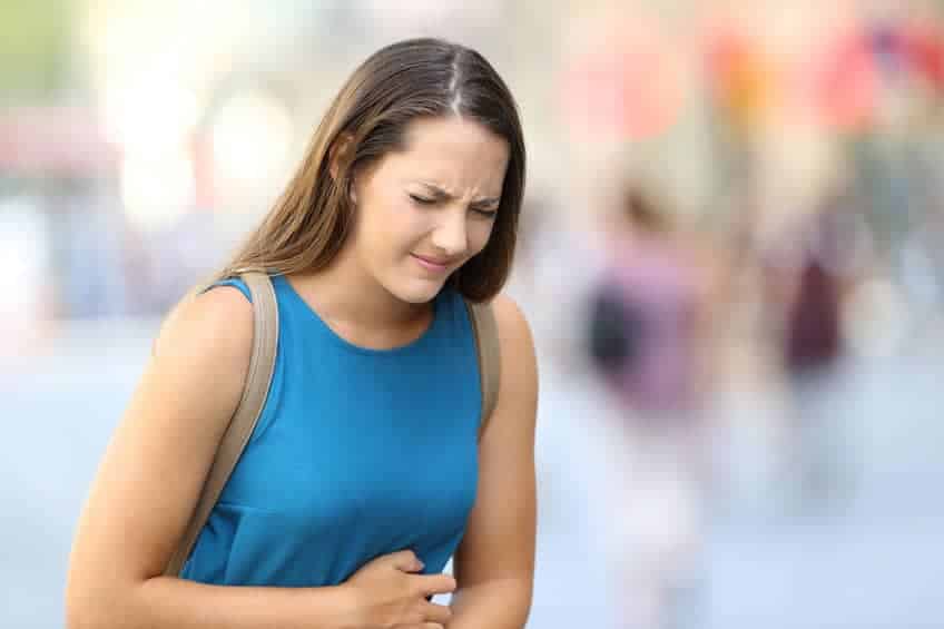woman suffering from abdominal pain and holding stomach