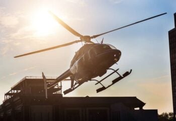 a helicopter taking off with sun in the background