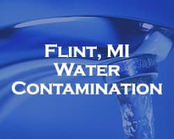 Flint Water Contamination - blue over a running faucet