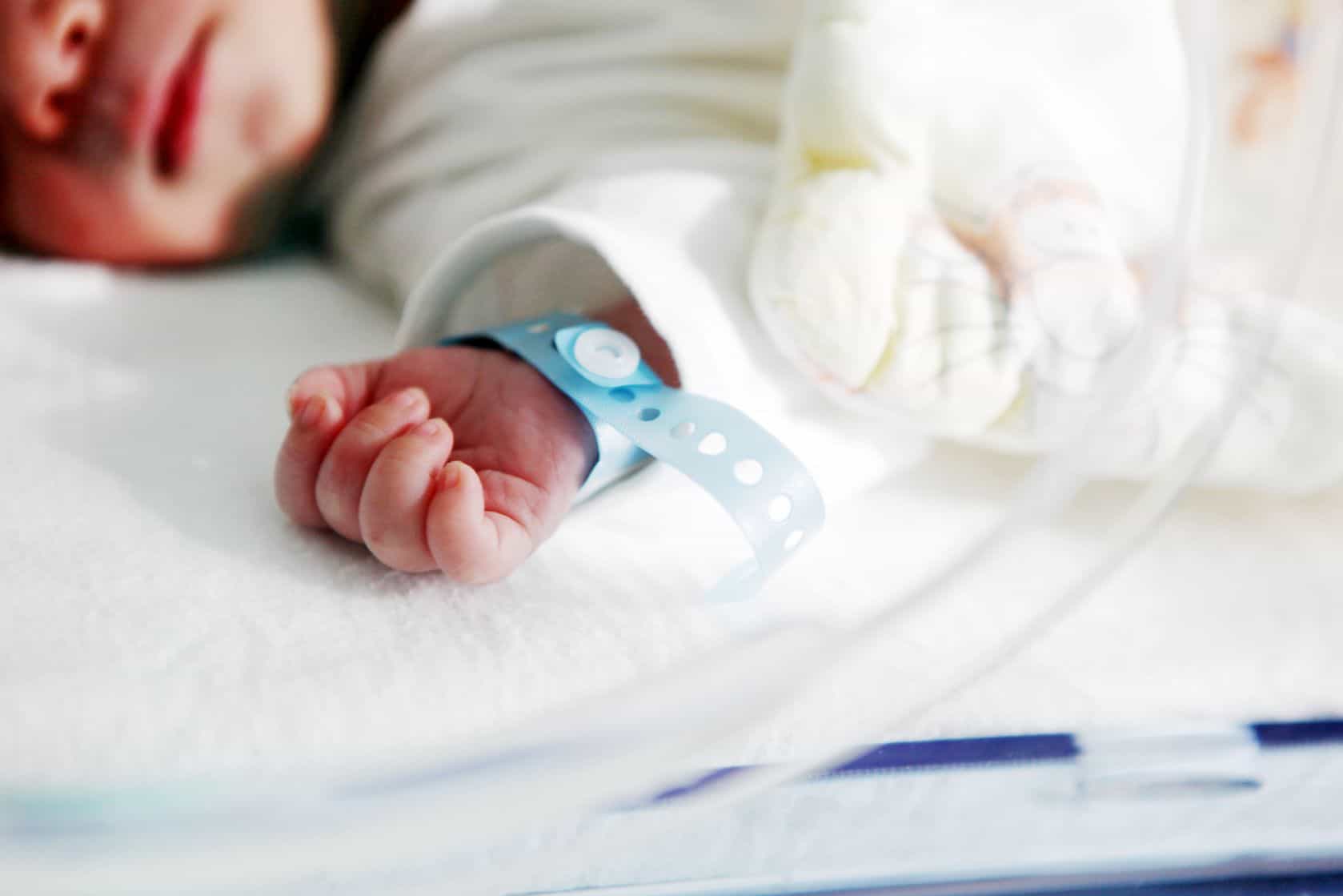 view of a baby's hand and face in the hospital