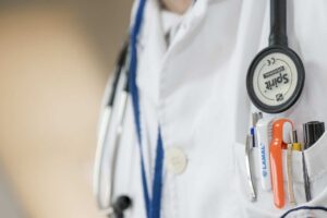 close up on a doctor's lab coat pocket and stethoscope