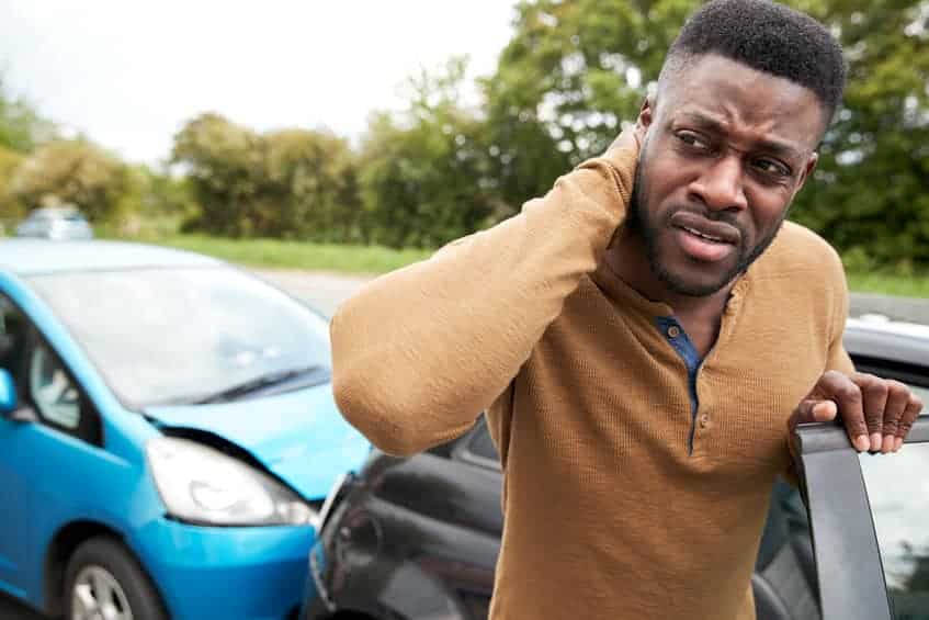 Male Motorist With A Whiplash Injury after a Car Crash Getting Out Of the Vehicle before calling The Barnes Firm Injury Attorneys