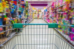 close up view of a shopping cart speeding through the aisles of a toy store