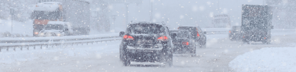 cars and trucks driving in snowy conditions