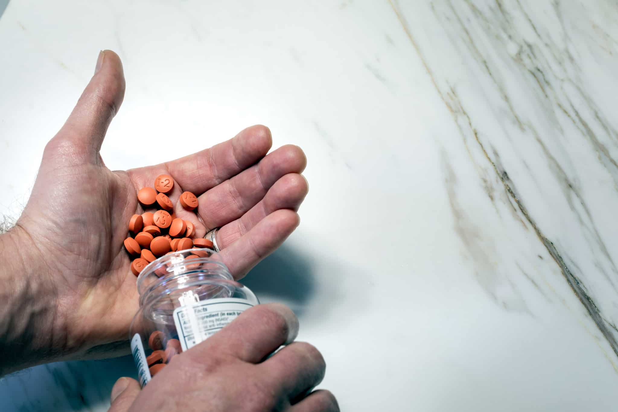 person pouring Tylenol into hand