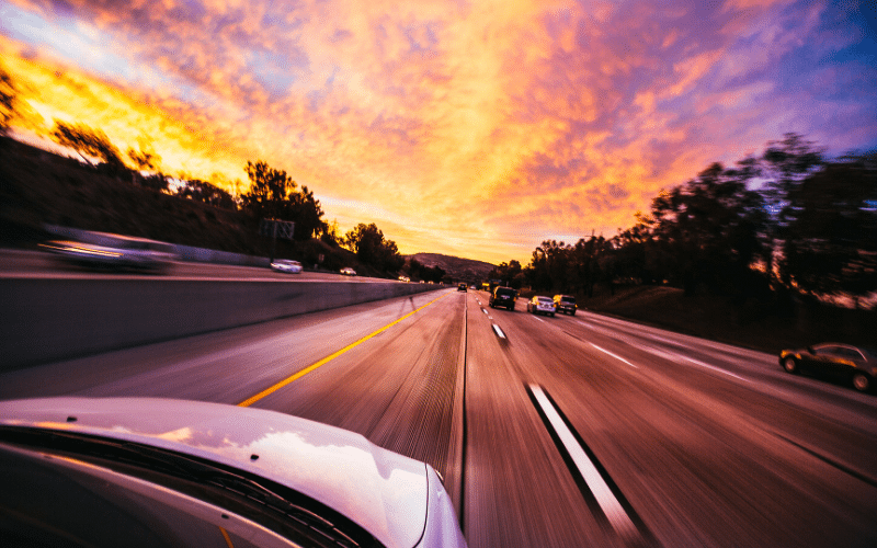 a car is driving home as the sky begins to get dark due to daylight savings time
