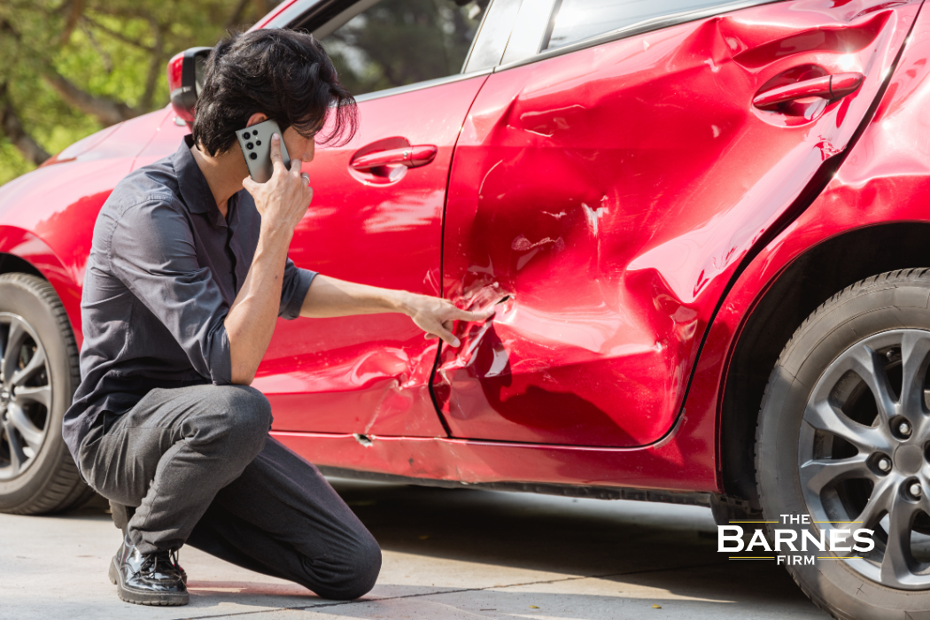 person looking at a dented car after a hit-and-run accident in Buffalo