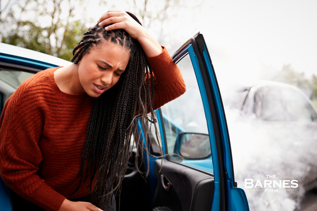 woman holding her injured head after a car accident